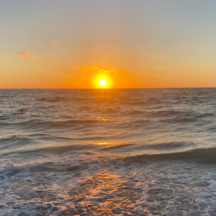 Golden sunset over the Gulf of America waves, casting warm autumn gold and orange tones suitable for Naples luxury decor.